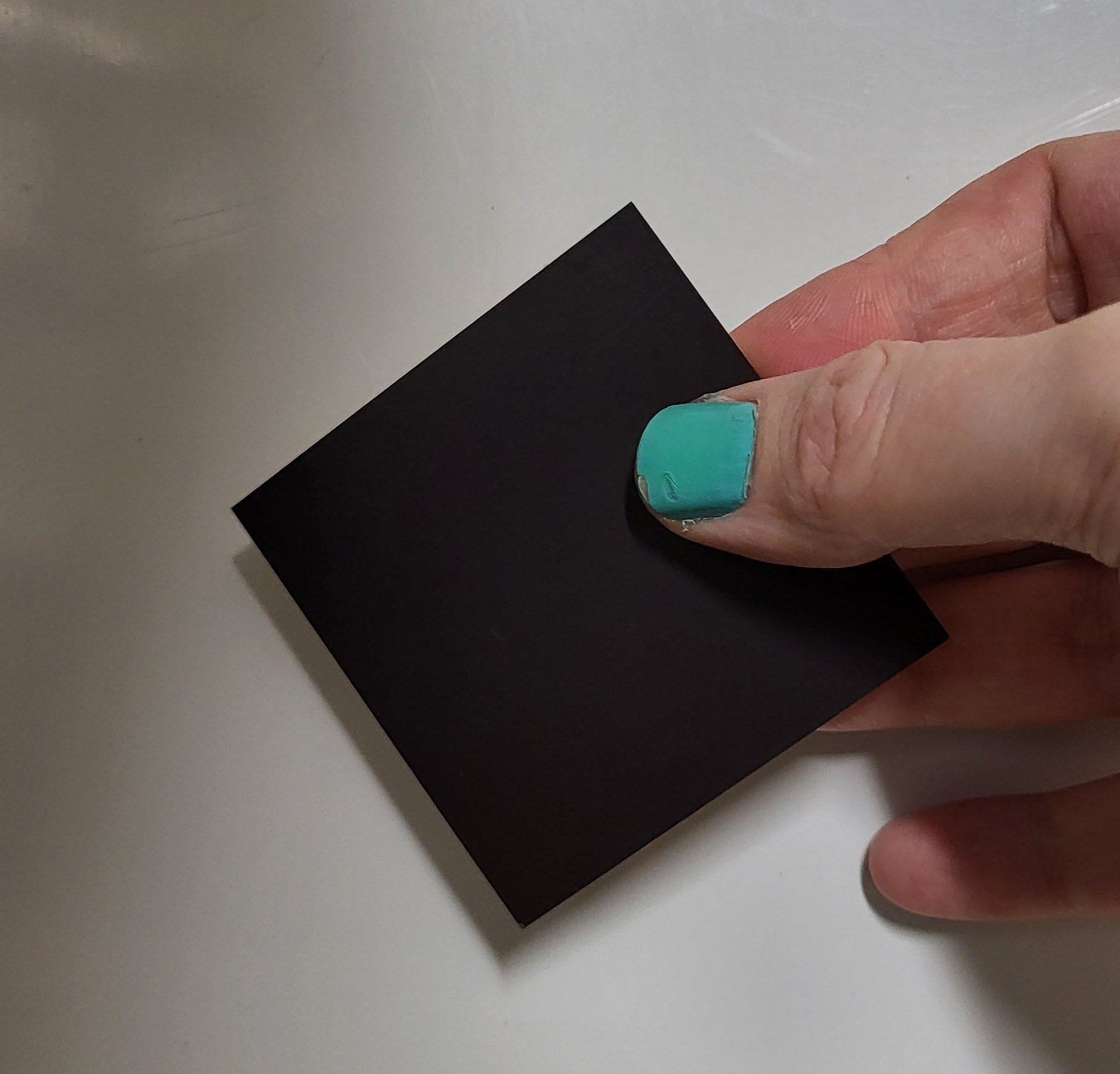 hand holding 2d magnet showing the back magnet 