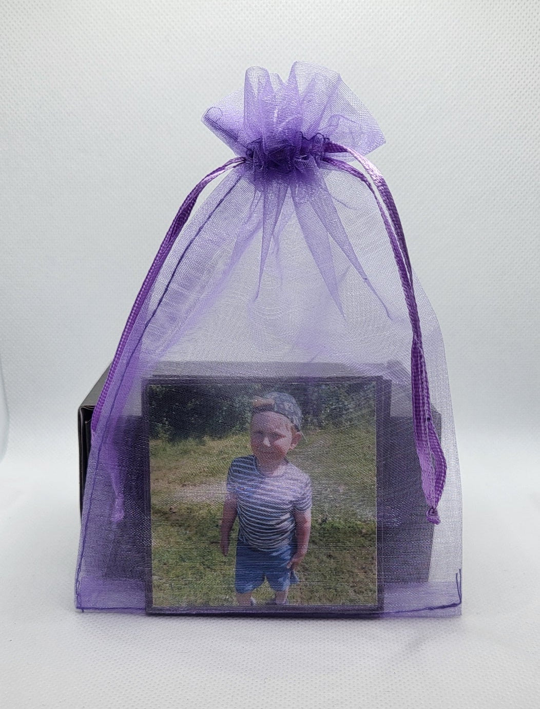 Purple organza bag with a photo of a person on a white surface